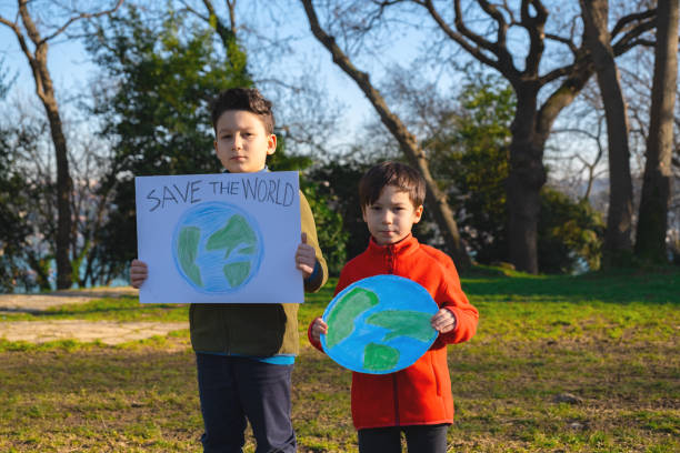 istock Child holding sign with world drawing in meadow 1370106354
