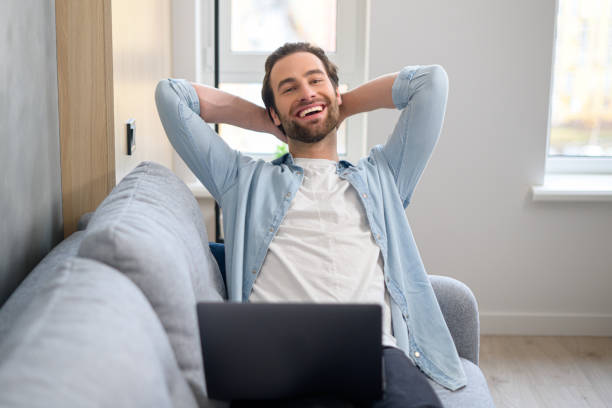 istock Handsome satisfied smiling freelancer guy holding arms behind head 1370106366