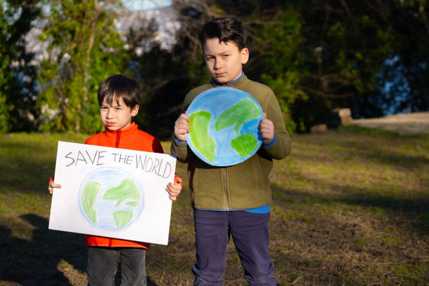 istock Child holding sign with world drawing in meadow 1370106959