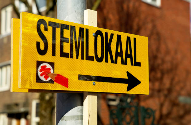 yellow sign referring to the polling station for municipal elections in the Netherlands 2022 Close up of a sign pointing to the voting booth for dutch city council elections absentee ballot photos stock pictures, royalty-free photos & images