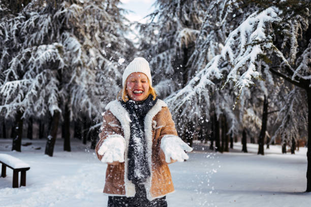 istock Young woman throwing a snow 1370112439