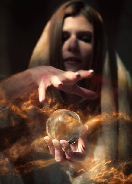 istock Seductive female fortune teller holding glass sphere with magical, glowing dust inside 1370114306