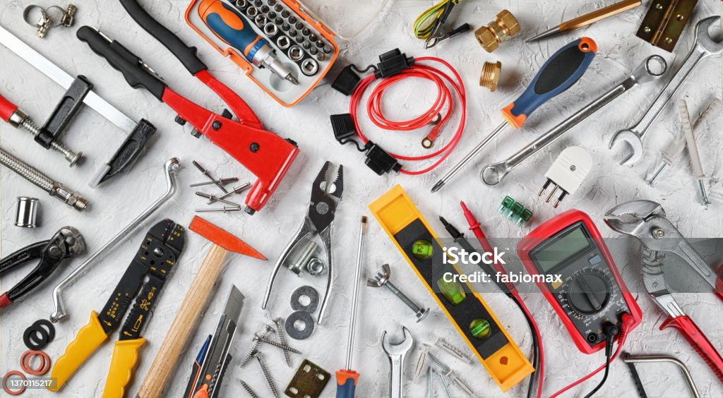 Set of hand tools on white plaster background. Work tools for electrician, carpenter, mechanic, plumber and hobist. Top view, flat lay. Handicraft and industrial tools, group of objects. Electrician Stock Photo