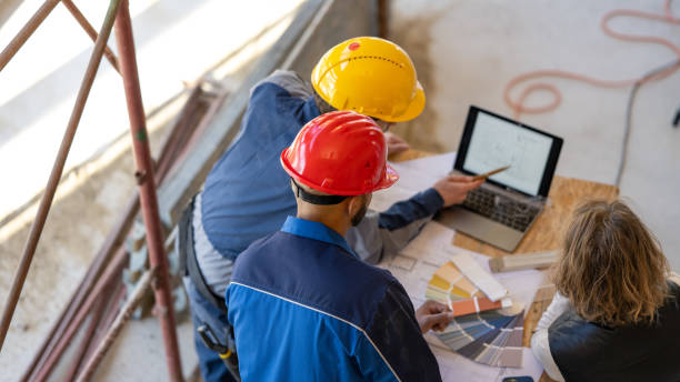 istock Group of people discussing over laptop screen on construction site 1370116717