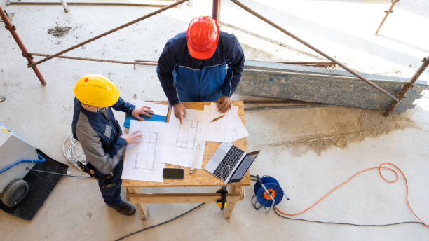 istock Colleagues on construction site, building specialists reading drawings 1370116735