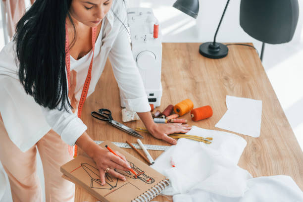 istock Busy at work. Seamstress is in her office that is with different clothes 1370118156
