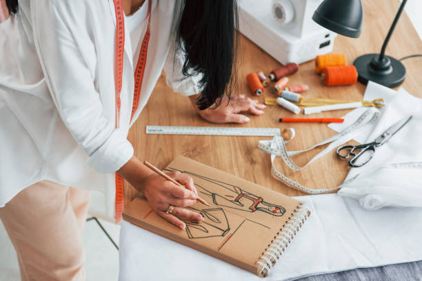 istock Working with precision. Seamstress is in her office that is with different clothes 1370118214