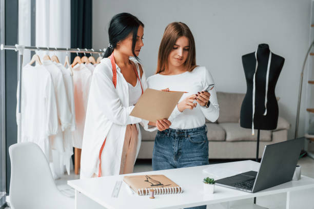 istock Talking with female customer. Seamstress is in her office that is with different clothes 1370118445