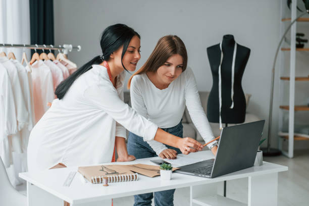 istock Talking with female customer. Seamstress is in her office that is with different clothes 1370118462