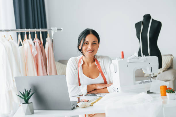 istock Professional sewing machine. Seamstress is in her office that is with different clothes 1370118585