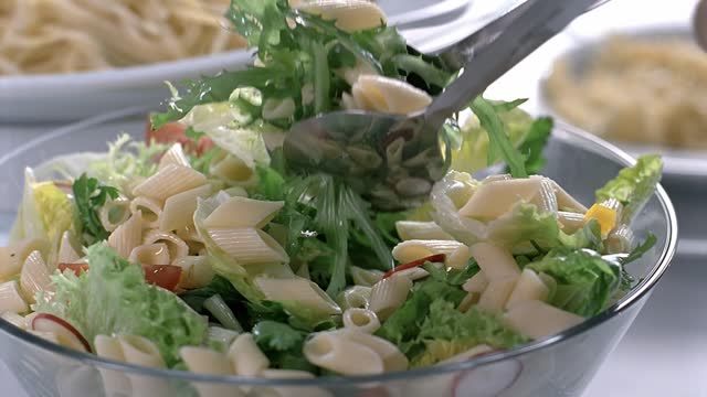 Do not mix the pasta and salad. Slow and close up video.
