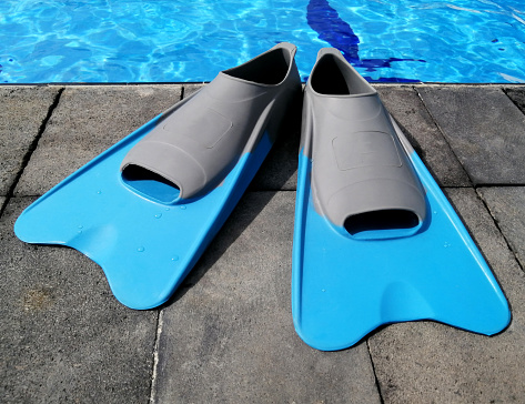 Swimming fins at swimming pool side. Open toe and closed heel for professional swimming and training