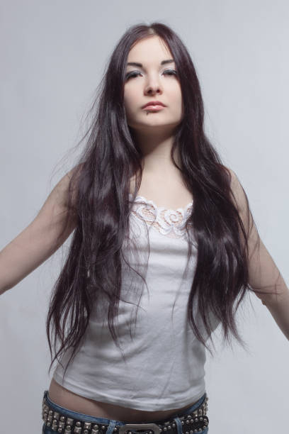 Pretty asian girl posing over grey background