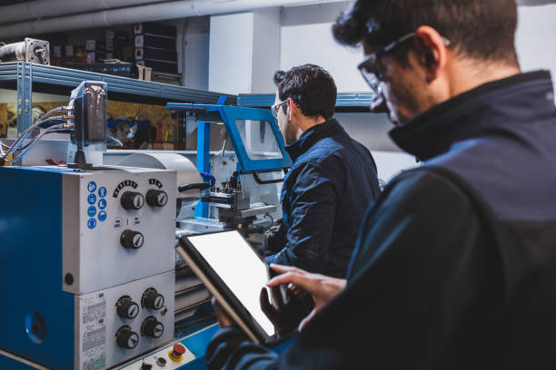 técnicos mecânicos que operam o centro de máquinas de corte de fresagem da cnc na oficina de ferramentas. - fresadora - fotografias e filmes do acervo