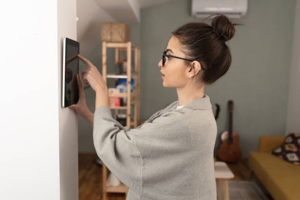 istock Young woman adjusting a smart house system 1370125502