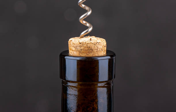 closeup of a corkscrew inside a wine cork in a bottle. - wine bottle wine wood bottle stopper imagens e fotografias de stock