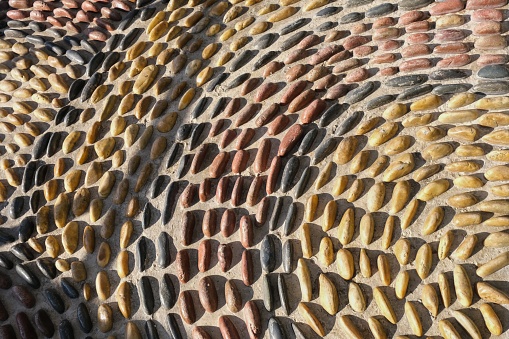 Fragment of reflexology cobblestones pathway for foot massage . Mosaic circle pattern from convex rounded pebble stones. Ground path textured surface from boulders.