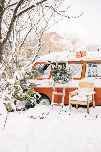 Snow covered van in winter camp, with Christmas decoration.