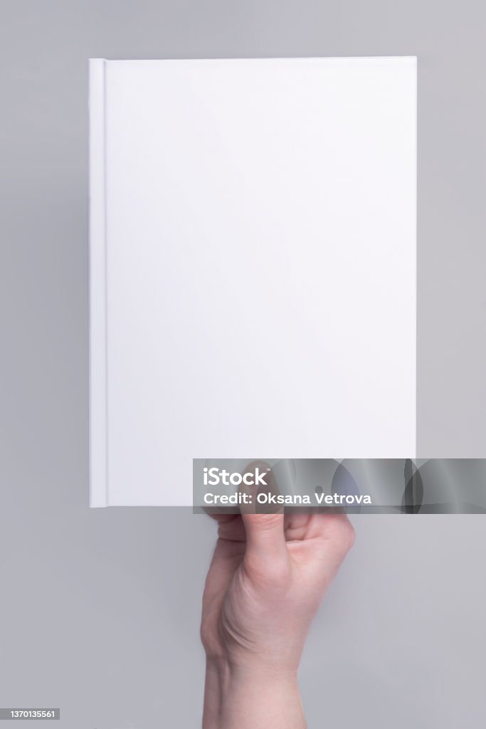 mockup of a white hardcover book cover in hand. Applicable for design presentation Covering Stock Photo