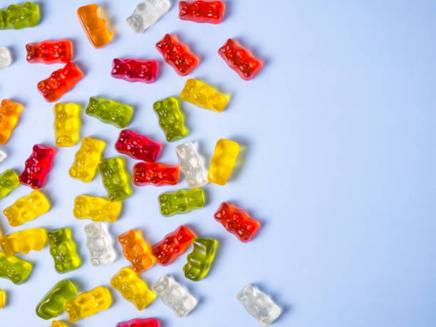 istock Delicious bright gummy bears on a blue background, flat lay 1370139496