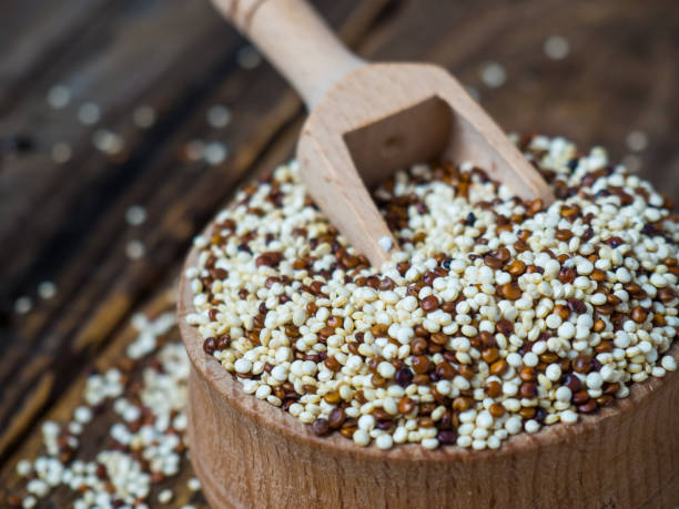 istock Quinoa in wooden bowl and scoop on rustic background 1370139540