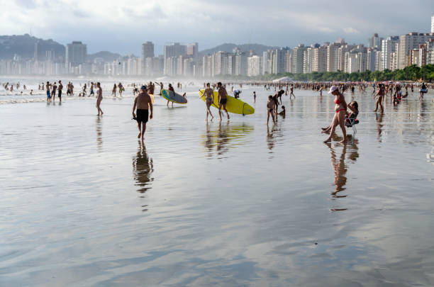 Salvador, Bahia, Brazil - June 04, 2022: Street vendors walk on the sand of Porto da Barra beach in Salvador, Bahia.