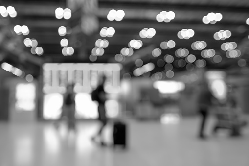 Blurred background of people traveling in Airport. Black and White tone.