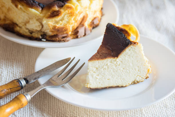 istock Basque Burnt San Sebastian Cheesecake with cutted piece on a white plate on light background, selective focus 1370146616