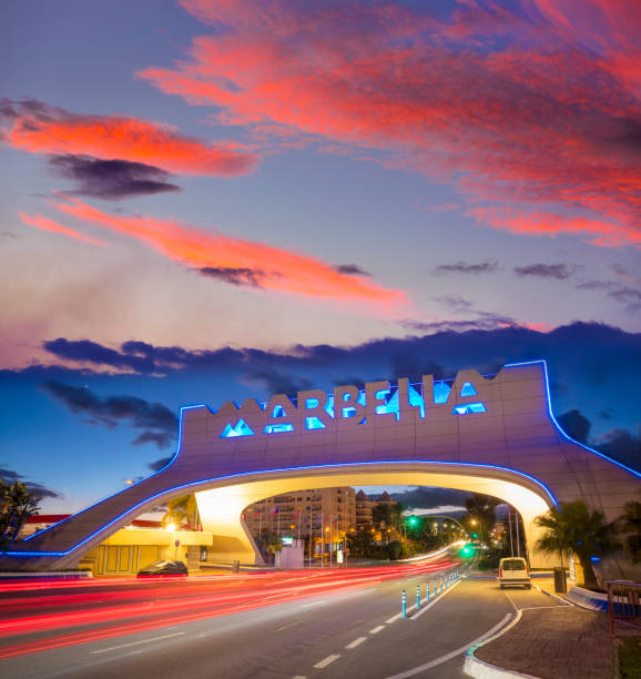 istock Marbella arch welcome sign at sunset with traffic light beams in 1370148093