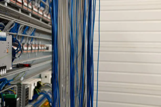 A closeup of gray and blue electrical wires in a factory