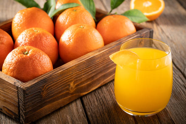 istock Orange juice with orange fruits on rustic wooden table fresh 1370152242