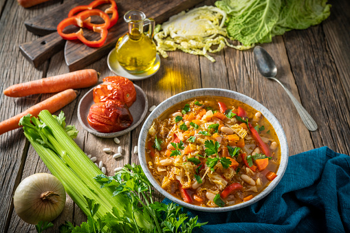 Vegetable Cabbage Soup vegan ingredients as celery, beans, bell pepper, carrots, parsley and roasted tomatoes. Healthy and delicious winter soup, we can switch cabbage for any other crucifer vegetables, plant based diet.