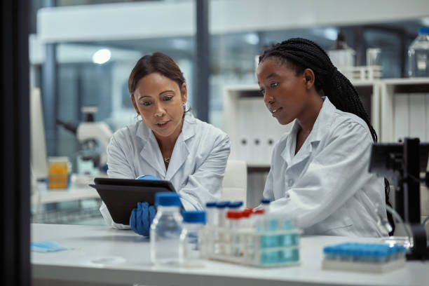 Shot of two scientists working together on a digital tablet in a lab stock photo
