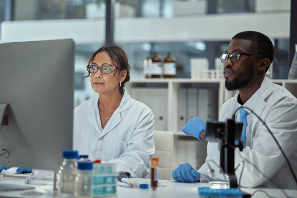Shot of two scientists working together on a computer in a lab stock photo