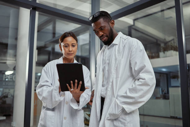 Shot of two scientists working together on a digital tablet