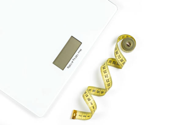 istock Modern scales and tape measure isolated on white, top view 1370154498