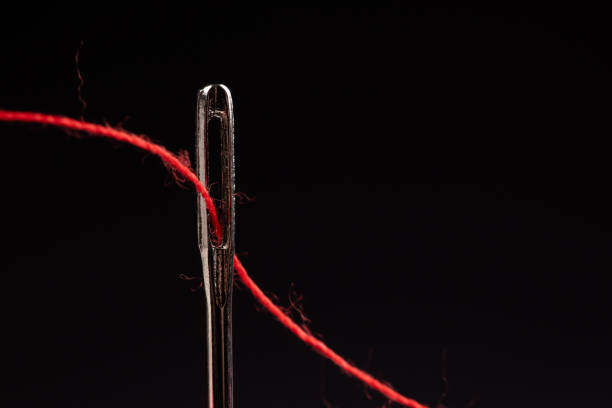 red thread and needle on black background - thread needle sewing red imagens e fotografias de stock