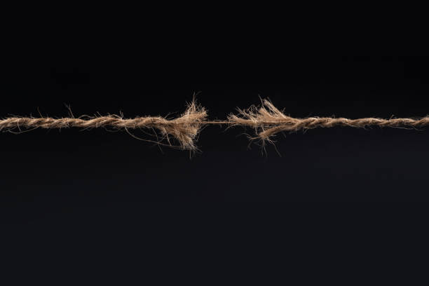 istock Frayed rope ready to break isolated on black background 1370155347