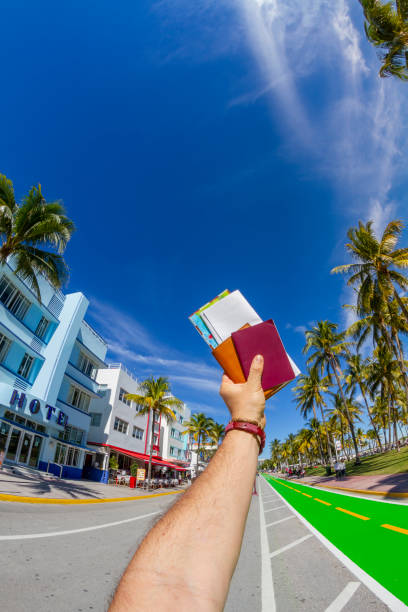 POV Point of view shot of a young travel male enjoying his vacations while holding his passport, a map and a boarding pass airline ticket in front of Ocean Drive, Miami, USA. POV Point of view shot of a young travel male enjoying his vacations while holding his passport, a map and a boarding pass airline ticket in front of Ocean Drive, South Beach, Miami Beach, Miami, South Florida, United States of America
The picture was taken at the famous and touristic Art Deco District. Shooting from a personal perspective in an exotic tropical beach travel holidays.
Travel Concept. 1 hotel south beach stock pictures, royalty-free photos & images