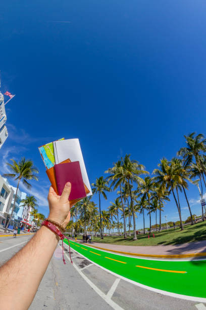 POV Point of view shot of a young travel male enjoying his vacations while holding his passport, a map and a boarding pass airline ticket in front of Ocean Drive, Miami, USA. POV Point of view shot of a young travel male enjoying his vacations while holding his passport, a map and a boarding pass airline ticket in front of Ocean Drive, South Beach, Miami Beach, Miami, South Florida, United States of America
The picture was taken at the famous and touristic Art Deco District. Shooting from a personal perspective in an exotic tropical beach travel holidays.
Travel Concept. 1 hotel south beach stock pictures, royalty-free photos & images