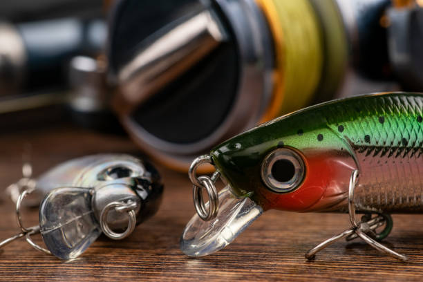 leurres de pêche colorés, wobbler, spinner, sur un bureau en bois différents appâts de pêche. - crank bait photos et images de collection