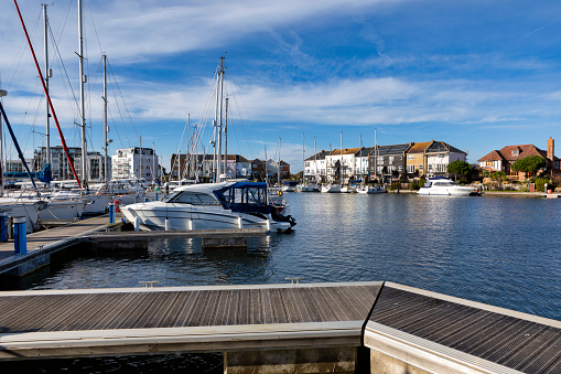 Big Lake Sentenberg. City harbour. Blue sky. Calm water. Lots of boats and yachts at the pier. A beautiful place to relax in nature near the water. Germany. \n  Without people