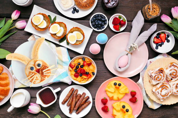istock Fun Easter breakfast or brunch table scene. Top down view on a dark wood background. 1370168503