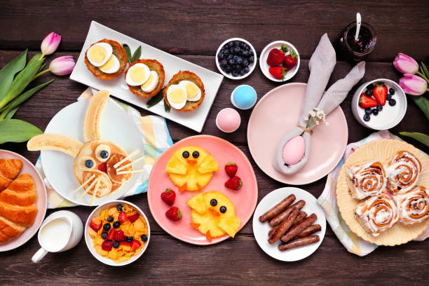 istock Fun Easter breakfast or brunch table scene. Overhead view on a dark wood background. 1370168507