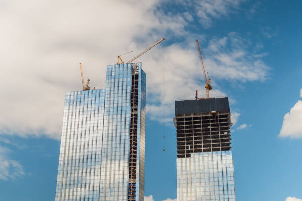 istock Yellow tower cranes and unfinished building construction 1370173956