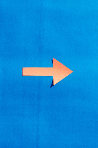 A right facing arrow indicating right direction. Isolated on blue background. Useful for signage and for way finding and surface markings.