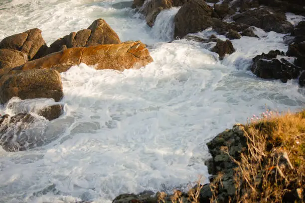 Photo of waves breaking on the rocks