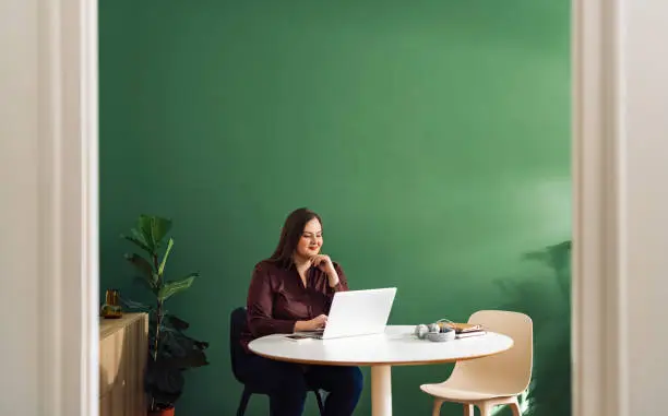 Photo of Beautiful Plus Size Businesswoman Working at Home on her Laptop Computer