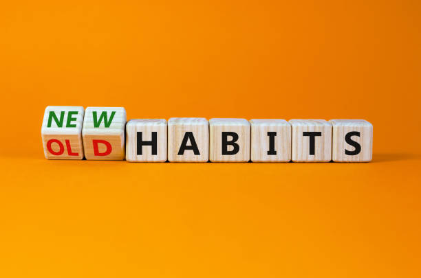 symbole d’habitudes nouvelles ou anciennes. des cubes de bois tournés, des mots « vieilles habitudes » en « nouvelles habitudes ». belle table orange, fond orange. concept d’affaires, d’anciennes ou de nouvelles habitudes. espace de copie. - addiction photos et images de collection