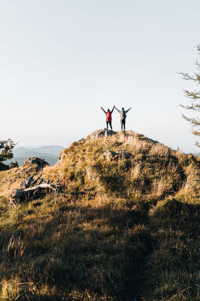 istock Young couple of backpackers celebrate on a mountain summit 1370188519